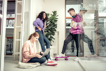 Red-haired student sitting on floor with her laptop before exam