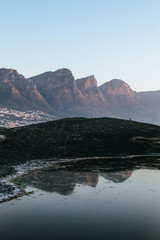 Moody, landscape of the 12 apostles mountains reflection in a water pool at Maiden's Cove in Cape Town 