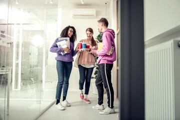 Fototapeta premium Handsome student bringing takeaway coffee for his best friends