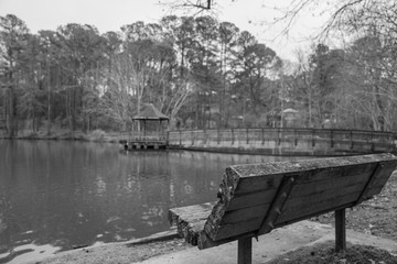 bridge to gazebo with park bench in foreground