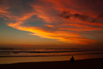 Young man sitting outdoors watching the sunset. Thinking and relaxing concept, Australia
