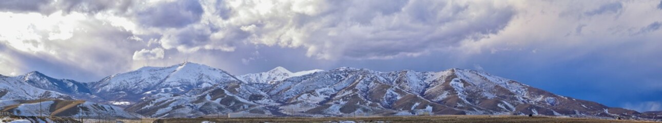 Fototapeta na wymiar inter Panorama of Oquirrh Mountain range snow capped, which includes The Bingham Canyon Mine or Kennecott Copper Mine, rumored the largest open pit copper mine in the world in Salt Lake Valley, Utah. 