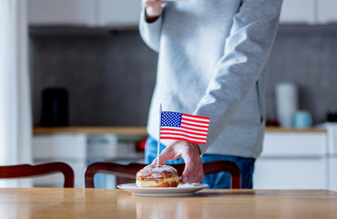 donut with USA flag on white plate on wooden table at kitchen