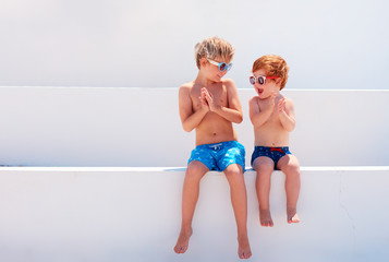 happy kids, brothers in swimmimg trunks playing together