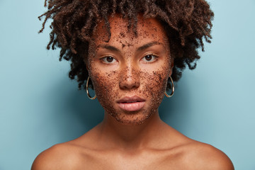 Skin care and cosmetology concept. Beautiful dark skinned serious female model has brown coffee...