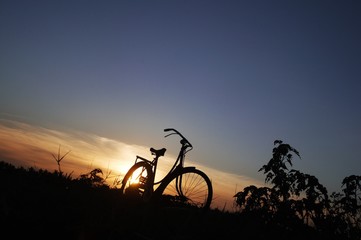 Fototapeta na wymiar Silhouette of old bike with sunset light
