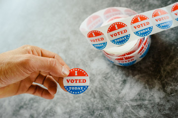 Man hand holding supporter stickers of american elections