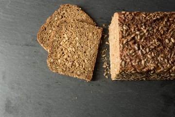 Sliced, fresh loaf of german rye bread - from above on slate - copy space