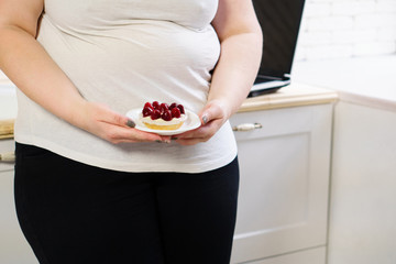 imbalanced nutrition, sugar addiction, dieting, weight loss concept. young overweight woman fed up with diets eating a cake.