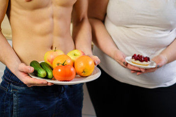 weight loss, motivation, fitness, diet, lifestyle, choice. fit muscle man with healthy food and overweight woman with sugary cake