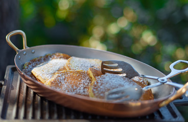 Closed up pancake with icing on copper pan