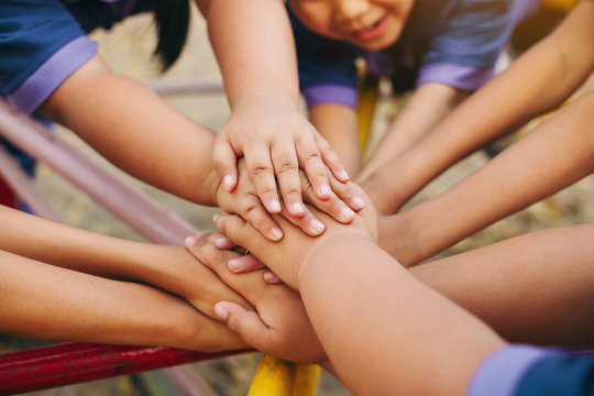 Group of diverse kids hands of together joining for teamwork, community,  togetherness and collaboration concept.