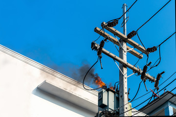power pylon overload or electric short circuit at transformer on poles and fire or flame with smoke...