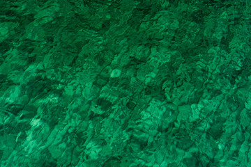 Green abstract texture background of emerald green sea water. Top view of green sea water with...
