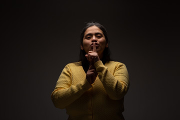 Hispanic Woman Commanding Silence Using Gesture with Finger