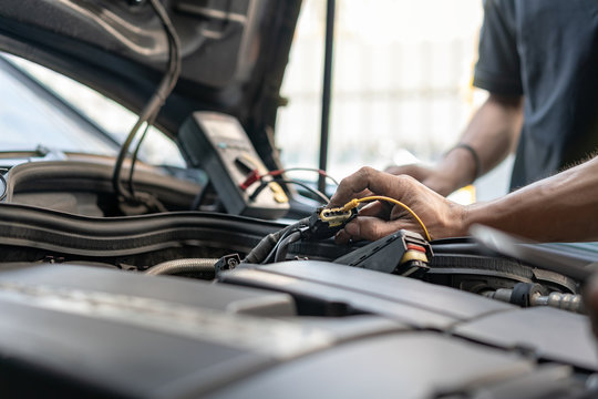 Close Up Tool And Hand Of People Or Mechanic Car Repair During Use Digital Multi Meter Investigate Cause Of Problem (electric System Check) Or Working On Automobile Gasoline Or Diesel Engine At Garage