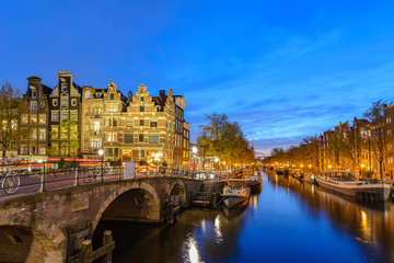 Fototapeta premium Amsterdam Netherlands, sunset city skyline of Dutch house at canal waterfront