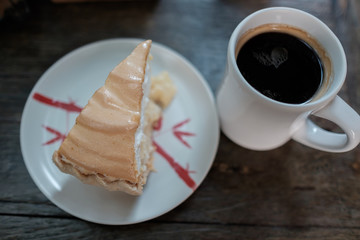 cup of coffee and coconut pie on wooden table
