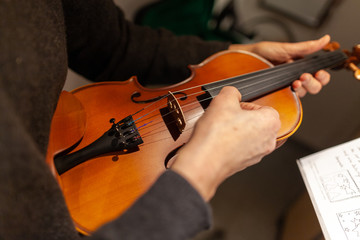 A woman plays a violin in a room