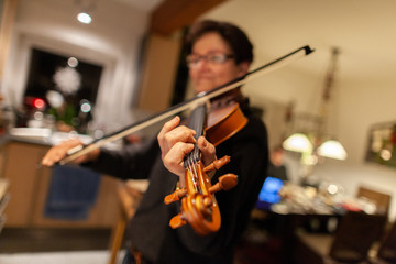 Fototapeta na wymiar A woman plays a violin in a room