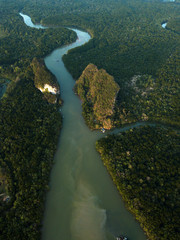 Image from drone of river in Krabi town, Thailand. Green trees, mountains and rocks around river.