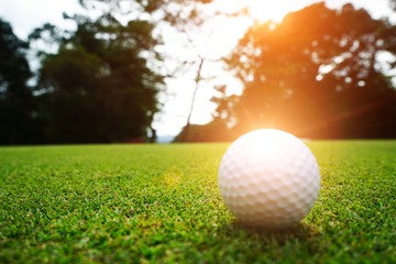 Blurred golf ball in beautiful golf course with sunset. Golf ball close up in golf coures at Thailand