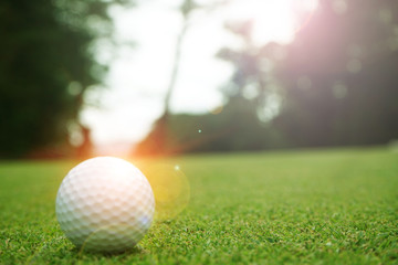 Blurred golf ball in beautiful golf course with sunset. Golf ball close up in golf coures at Thailand