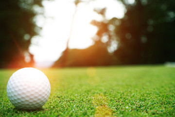 Blurred golf ball in beautiful golf course with sunset. Golf ball close up in golf coures at Thailand