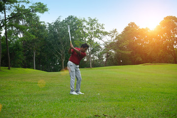 Blurred golfer playing golf in beautiful golf course in the evening golf course with sunshine in...