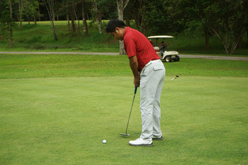 Fototapeta premium Blurred golfers are putting golf in the evening golf course golf backglound in Thailand