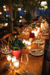 Close up shot of  decorated table with no people. Dining table with plates, wine glasses and candles.