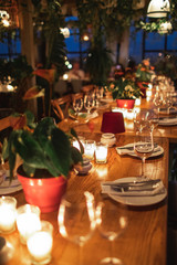 Close up shot of  decorated table with no people. Dining table with plates, wine glasses and candles.