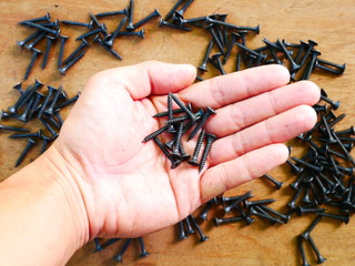 black metal screw,pile of nails wood background
