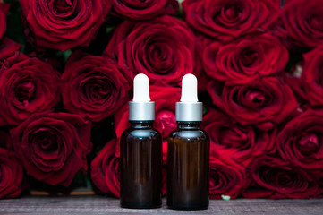 Rose oil,   Bottles  and fresh flower and leaves on a natural  background,  bio, organic , nature cosmetics concept