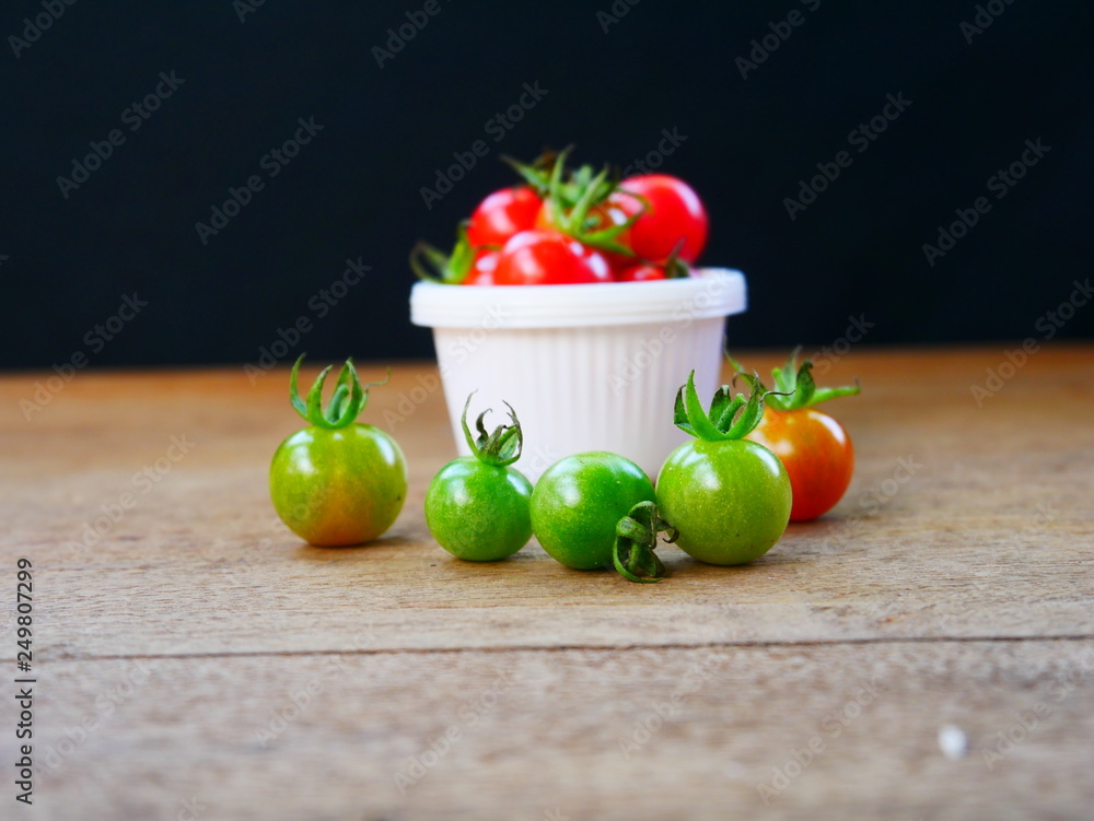 Wall mural red cherry tomato on wood background