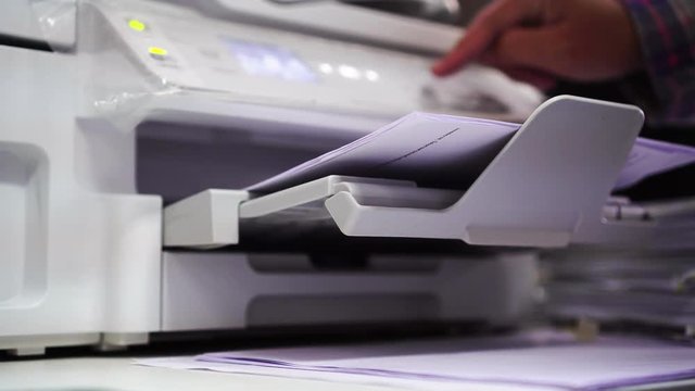 Business office Concept : Hand Businessman is process of press paper on laser print cartridge, lay down or take papers from printer at Busy Offices background