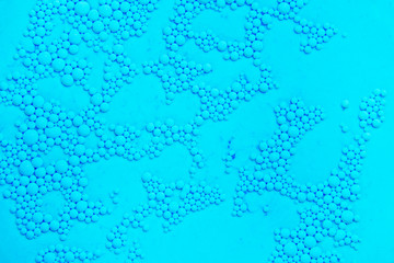 Drops of oil on the surface of the water. Abstract colored background.