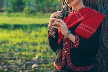 Young woman playing bamboo flute