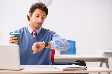 Young handsome employee working in the office 