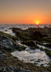 seascape sunrise with moss and water flow