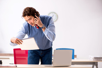 Young handsome employee working in the office 