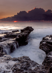 seascape, with flowing water and moody sunrise