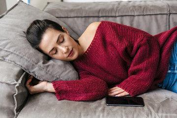 Woman indoors in home on sofa sleeping have a rest lies.