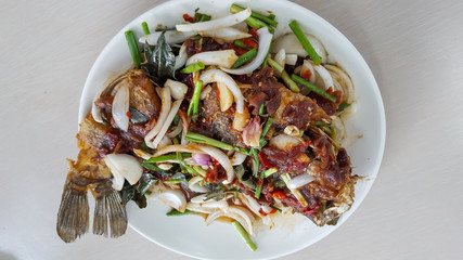.Fish with chili, put on a plate, placed on a white table