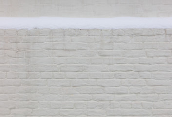 Snow on a white brick wall as background.