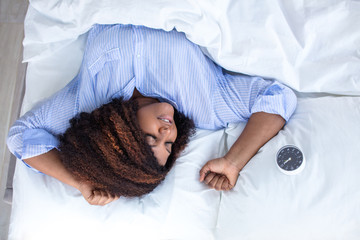 young woman enjoys sleeping, girl is lying in comfortable position in the bed