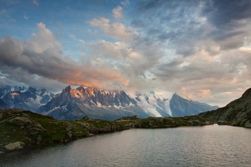 Alpine valley glowing by sunlight. Popular tourist attraction. Dramatic and picturesque scene with tent. Colorful summer panorama of the Lac Blanc lake with Mont Blanc on background, Chamonix, France