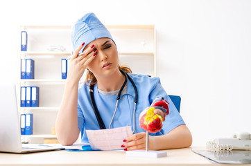 Young female doctor cardiologist sitting at the hospital 