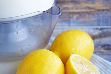 Squeeze the juice out of the lemon.Fresh lemons and citrus juicer on wooden background.