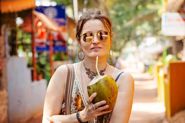 Woman on the street with young coconut drink - obrazy, fototapety, plakaty